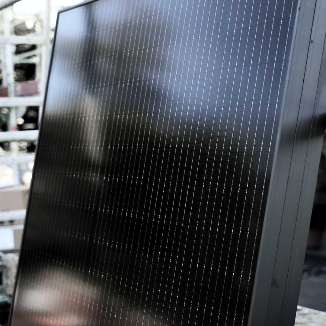 Detailaufnahme von glänzenden Solarpanels mit schwarzen Solarzellen im Sonnenlicht-1