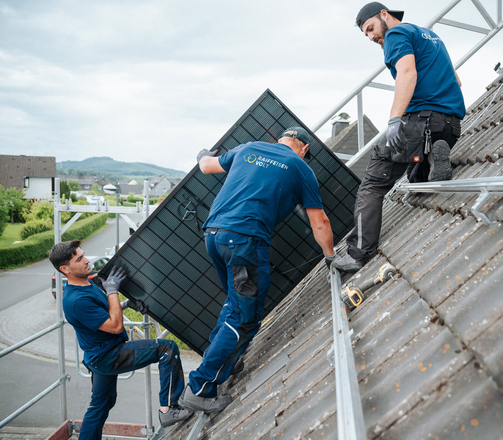 Montageteam von RaiffeisenVolt auf Dach mit Solarmodul