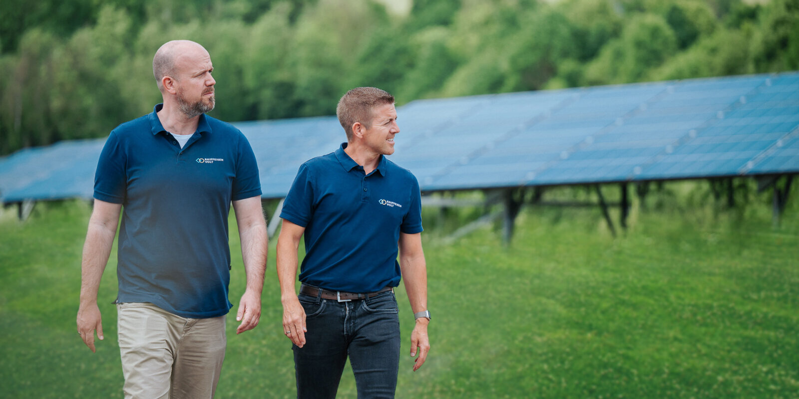 Zwei PV Experten gehen vor einer Anlage in Meschede