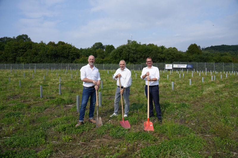 Photovoltaik-Berater mit Spaten bei Projektstart für Solarpark